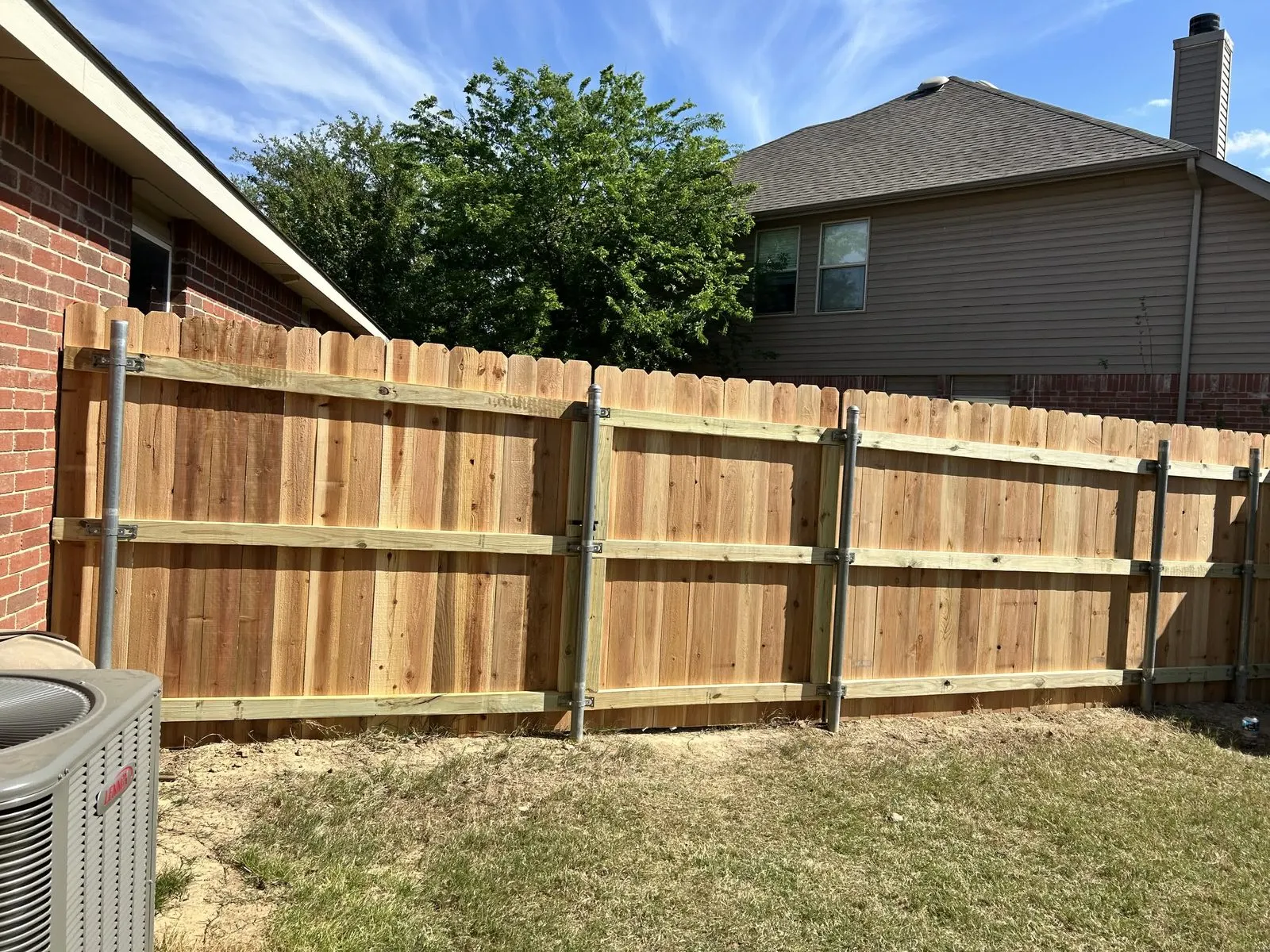 A finished wood privacy fence built by Ad Lib Family Construction in Cleburne, Texas.